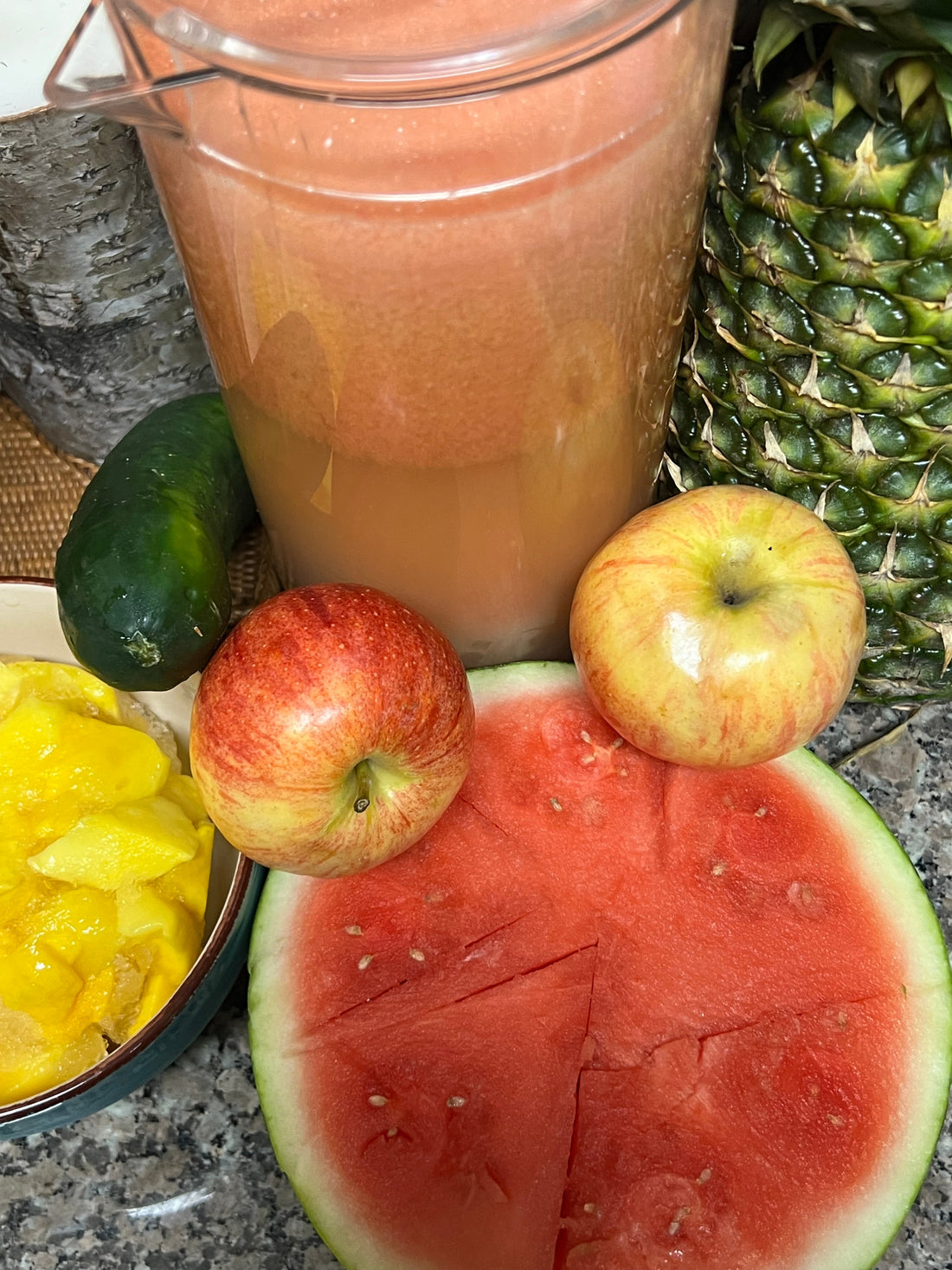 Fresh healthy smoothie with pineapple, watermelon, apples, mango and cucumber on kitchen counter