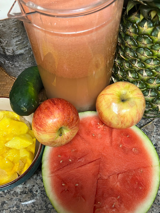 Fresh healthy smoothie with pineapple, watermelon, apples, mango and cucumber on kitchen counter